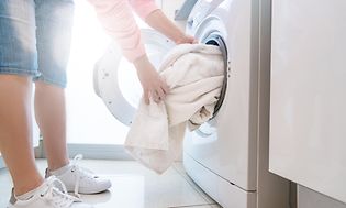 Kvinde tager tøj ud af tørretumbleren