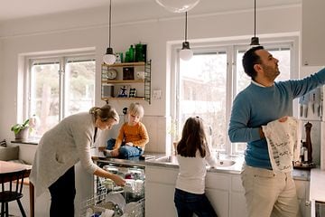 MDA-Dishwashers- Familie i et køkken, der tager et rent fad frem