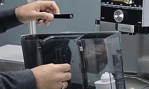 Hænder rengør en Siemens Espresso maskine