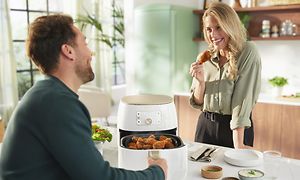 Philips Airfryer og en mand og en kvinde ved et bord
