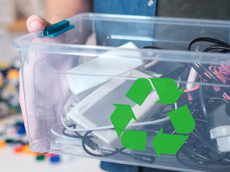 Bæredygtighed - Genbrug - En mand, der holder en kasse med gammel elektronik og et genbrugslogo