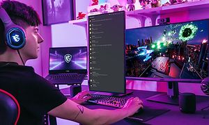 Gamer foran to skærme og en bærbar computer