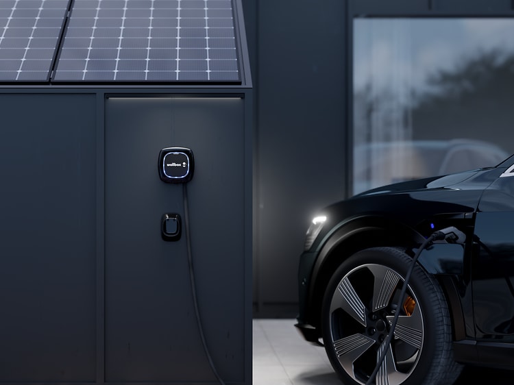 Wallbox monteret på et hus med solceller oplader en bil
