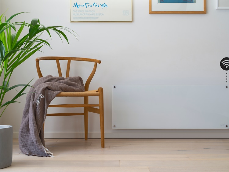 Smart radiator på væg med stol og plante