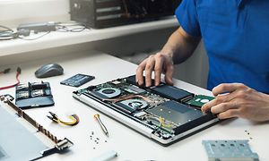 Computing - en mand, der erstatter en SSD på en bærbar computer
