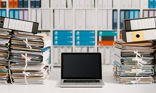 Computing - Computer i midten af stakke af papir