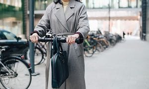 Tilbehør - Business kvinde kører en el-scooter med en laptop bag på styret