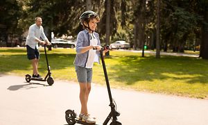 Wearables - Ung dreng på en el-scooter med sin far i baggrunden