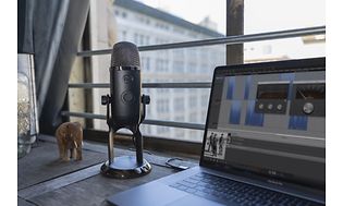 Yeti X-mikrofon på et skrivebord med en bærbar computer
