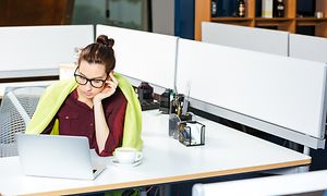 Kvinde med tæppe ved skrivebord