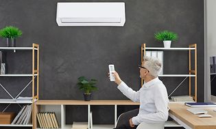 Mand tænder for aircontion på hjemmekontoret