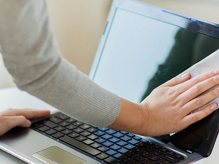 Computing - Laptop - Kvinde tørrer skærmen på sin laptop af