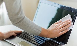Computing - Laptop - Kvinde tørrer skærmen på sin laptop af