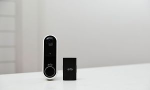 Arlo - Videoringeklokke og batteri på et bord