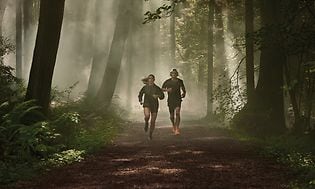 Garmin - Forerunner - To løbere, der løber i skoven 1600x600