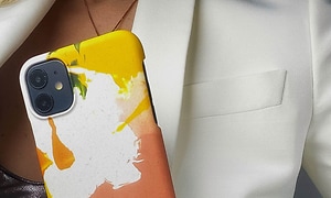 A Good Company - Et farverigt iPhone cover foran en kvinde i en blazer