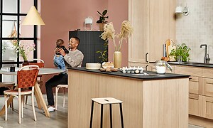 En mand og en baby sidder i et Epoq Shaker køkken i farven Natural Oak