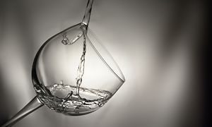 Vand der bliver hældt i krystalglas
