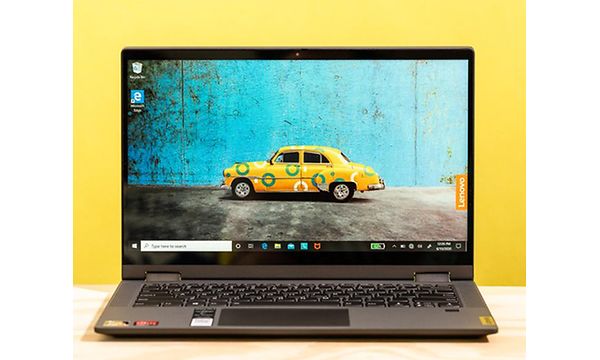 Lenovo IdeaPad Flex 5 på et bord med en gul baggrund