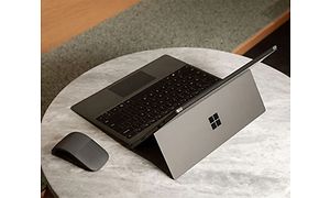 Microsoft Surface Pro 7 på et lille bord med en mus