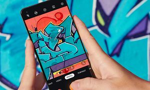 OnePlus - En person, der tager et billede af noget graffiti