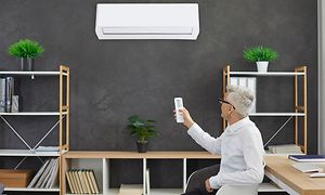 Mand tænder for air condition på sit hjemmekontor