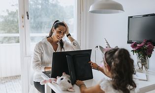 En kvinde med sin computer og datteren med sin tablet
