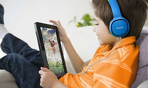 Et barn, der bruger en tablet, mens han har hovedtelefoner på