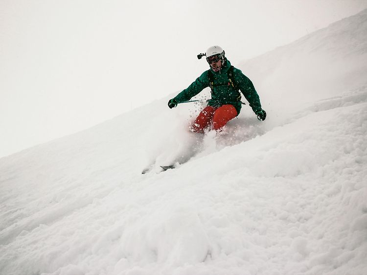 Mand står på ski med en GoPro på hjelmen