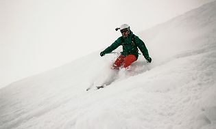 Mand står på ski med en GoPro på hjelmen