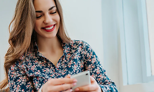 Smilende kvinde kigger på smartphone