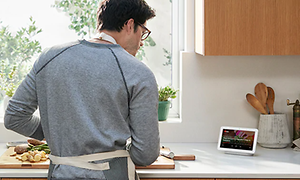 Google Nest Hub - en mand der laver mad mens han ser på skærmen