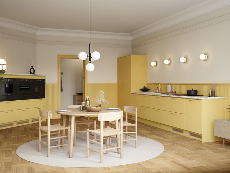 Gult EPOQ Trend-køkken med hvid bordplade og køkkenø med hvidevarer og skuffer, i en åben køkkenløsning med spisebord og stole