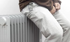 Person læner sig op af olieradiator