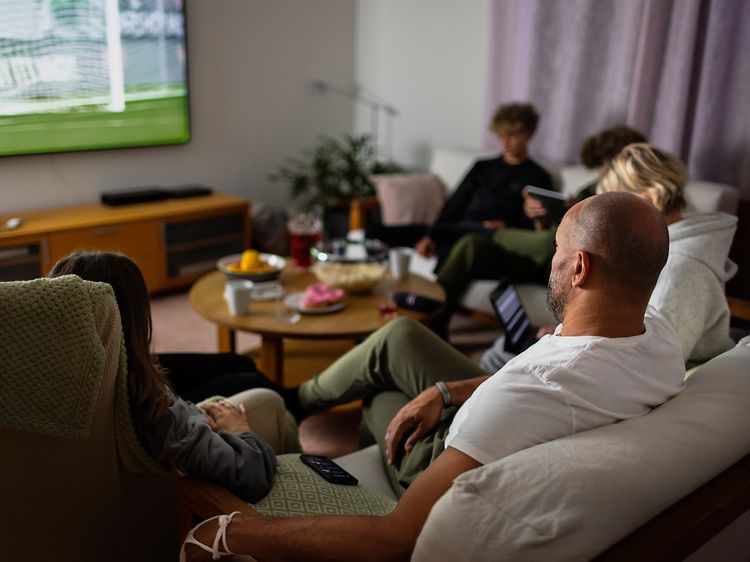 Familie i sofa ser tv