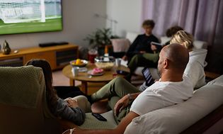 Familie i sofa ser tv