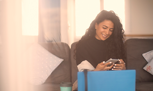 Kvinde ser smilende på telefon