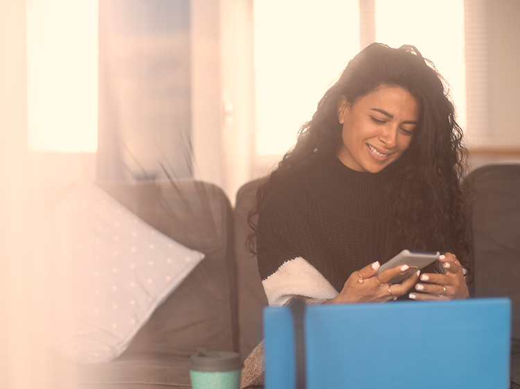 Kvinde ser smilende på telefon