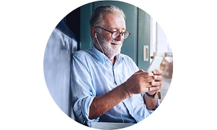 Mobilforsikring: En ældre mand kigger på sin mobiltelefon.
