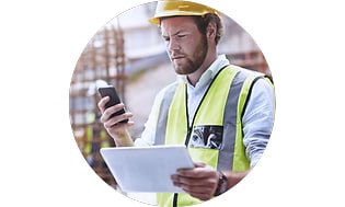 Mobilforsikring: Bygningsarbejder med en mobil i hånden