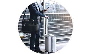 Mobilforsikring: Forretningsmand med bagage tjekker sin telefon