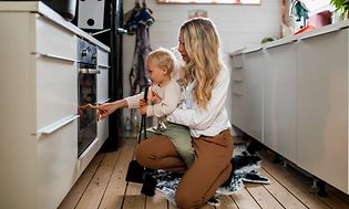 Kvinde og baby foran ovn