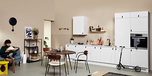 Epoq-køkken og ung mand, der læser i en sofa