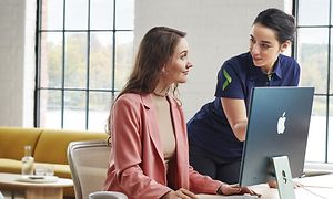 En kvindelig Elkjøp-medarbejder hjælper kvinde med at bruge sin iMac