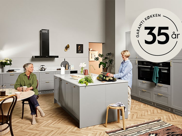 To kvinder i et Epoq-køkken og et 35-års garanti-logo