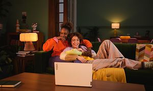Lenovo Yoga Slim 9 - Par i sofa som ser film på computer
