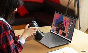 Lenovo Yoga Slim 7 Pro X - Kvinde med DSLR-kamera foran bærbar computer