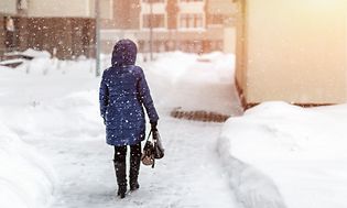 Kvinde ses bagfra på gade i snevejr