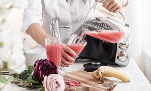 Kvinde hælder juice fra blenderen i et glas
