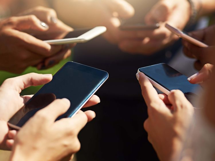 Telecom - Smartphone - Billede af en gruppe mennesker, der bruger deres mobiltelefoner synkront udendørs
